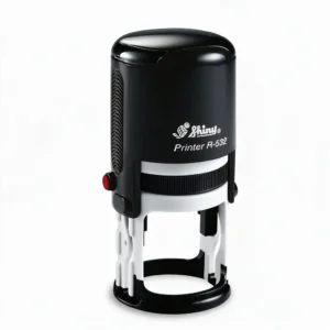 Cachet rond auto-encreur noir Shiny R-532 vu de face, corps noir brillant et base blanche à anneau, sur fond blanc